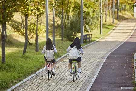 路背包骑高中生自行车公园背景图片