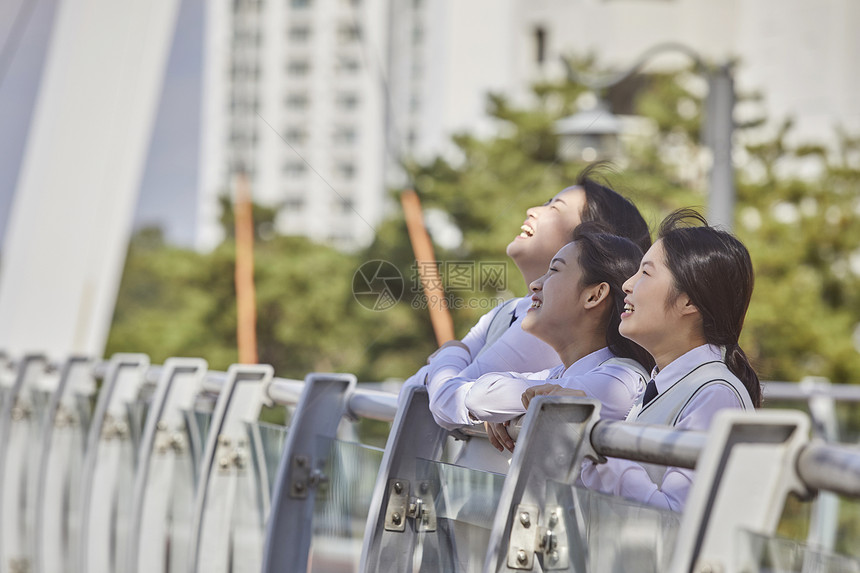 高中生在校园内趴在栏杆上聊天图片