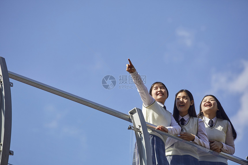 高中生在校园内趴在栏杆上聊天图片