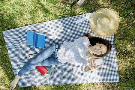 躺在公园草坪上微笑的女性图片