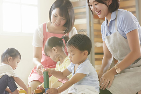 室内陪孩子们玩耍的幼儿园老师图片