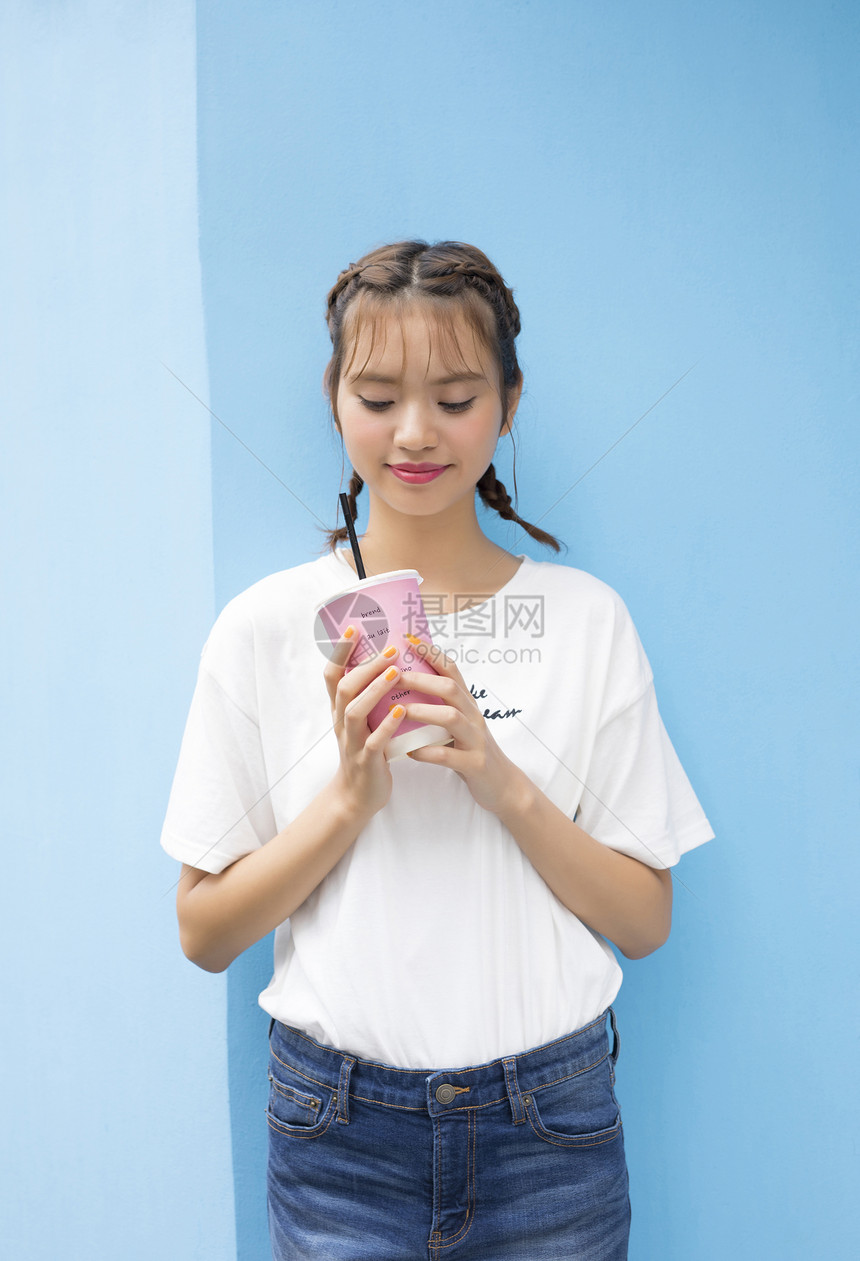 一个女人拿着奶茶图片