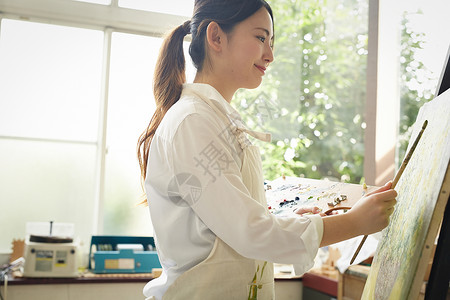 自然采光年轻女士认真绘画图片