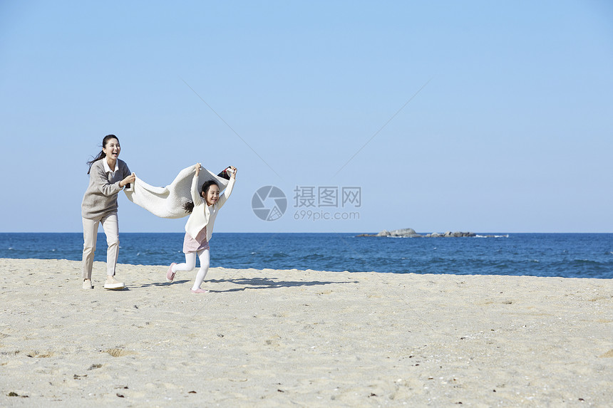 母女在沙滩上奔跑图片