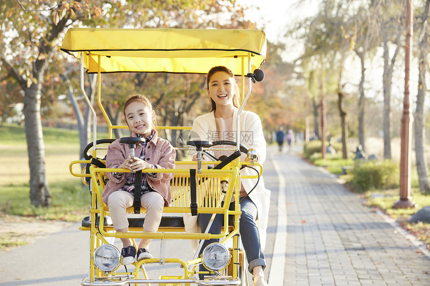 母女骑行双人自行车游览公园图片