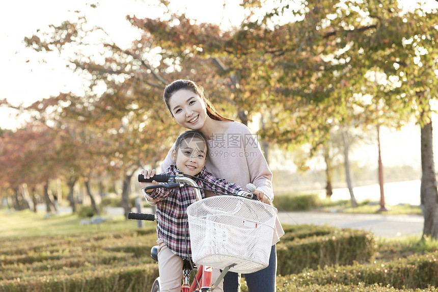 母女骑行双人自行车游览公园图片