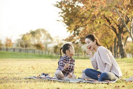 户外的秋天女孩母亲女儿公园野餐图片