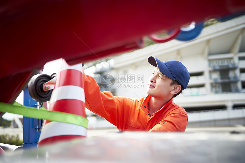 搬运放置路障锥桶的道路救援服务人员图片