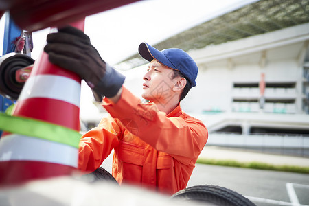 搬运放置路障锥桶的道路救援服务人员图片