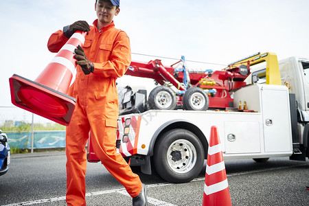 放置路障锥桶的道路救援服务人员图片