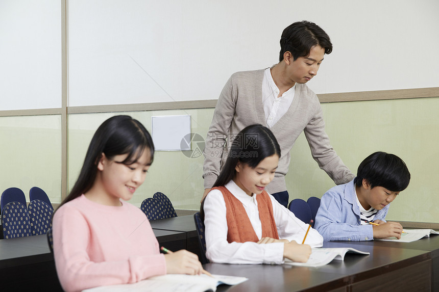 老师在教室里指导学生写作业图片