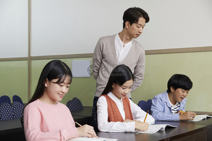 老师在教室里指导学生写作业图片