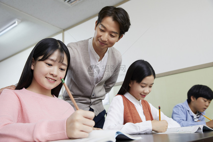 老师在教室里指导学生写作业图片