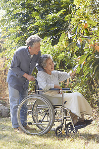 丈夫推坐轮椅的妻子外出散心护士高清图片素材