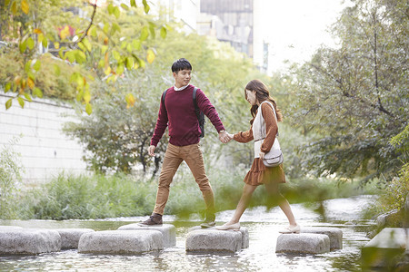 身前快乐亚洲人情人情侣约会溪流踏脚石图片