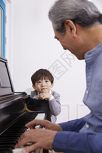 男孩看着爷爷弹奏钢琴韩国人高清图片素材