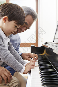 开心祖父教孙子弹钢琴住房高清图片素材