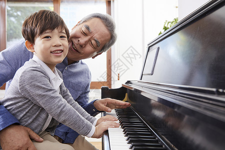 音乐成年男子微笑祖父孙子钢琴艺术高清图片素材