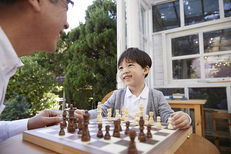 微笑祖父孙子下国际象棋成年男子高清图片素材