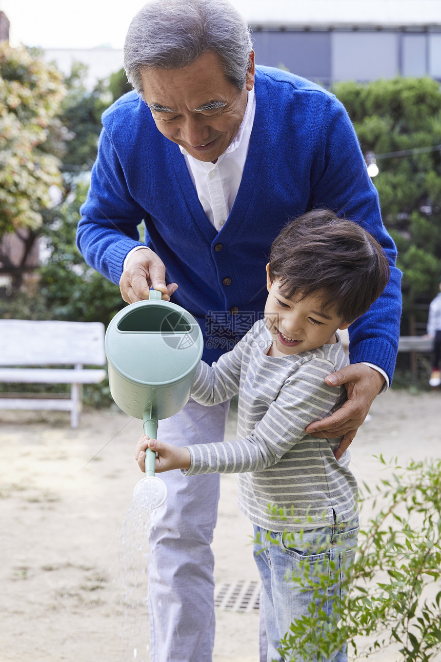 祖父孙子一起在浇水图片