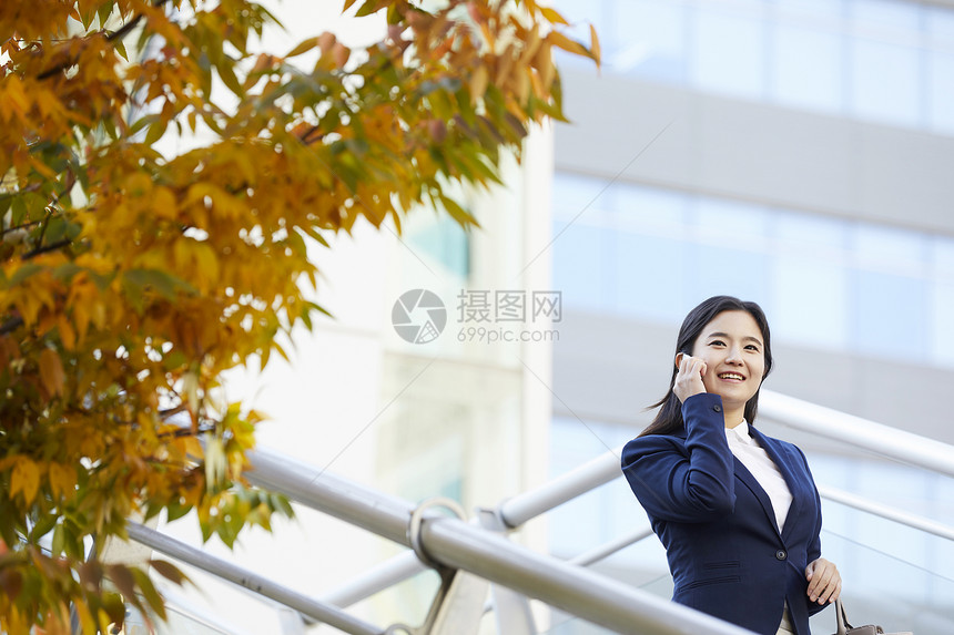 微笑着打电话的青年女性图片