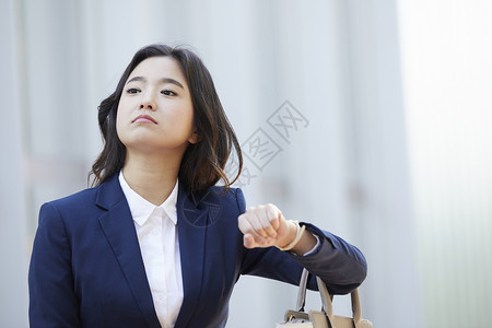 看着手表时间的成年女子图片