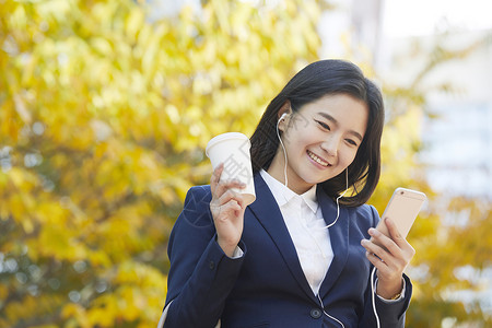 微笑着看手机的女青年图片