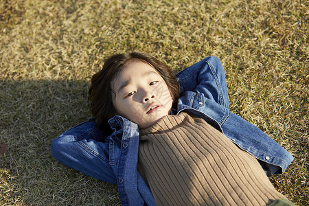 小男孩躺在草地上图片