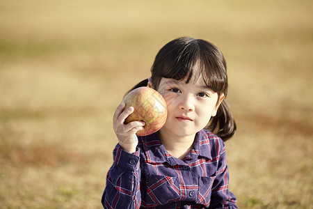 小女孩抱苹果小女孩抱着苹果背景