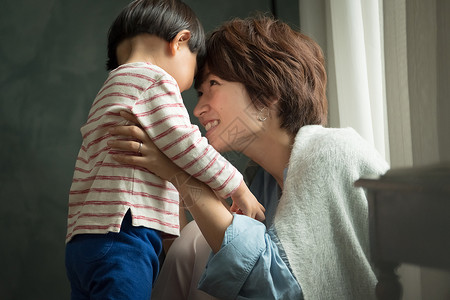 有趣在窗户旁小孩父母在客厅里放松图片