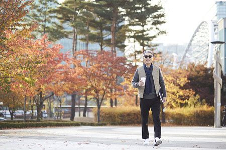 秋季老人在公园里走路背景图片