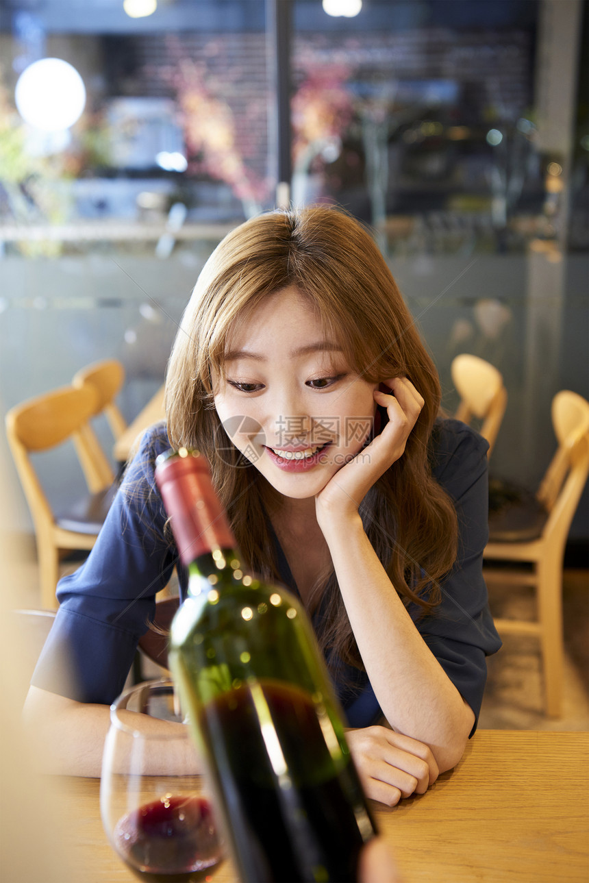 年轻女子酒瓶成立侍酒师顾客餐厅咖啡馆图片