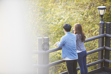 靠在栏杆上看风景的年轻情侣大学生高清图片素材