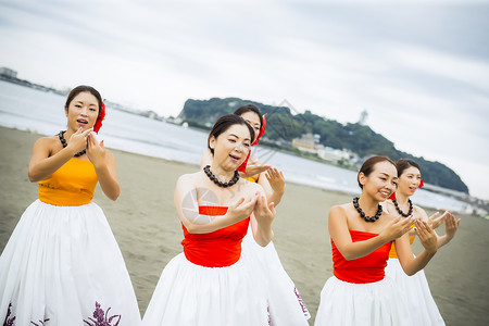 歌女欢快笑容跳舞在海滩的hula舞蹈家图片