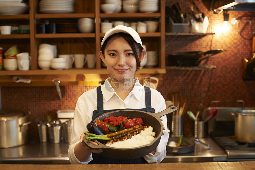 在咖啡店厨房认真工作的年轻男女图片