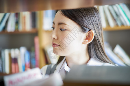 学校亚洲人天图书馆里的学生学习高清图片素材