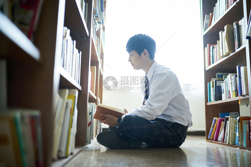 年轻人趺坐男孩们图书馆里的学生图片