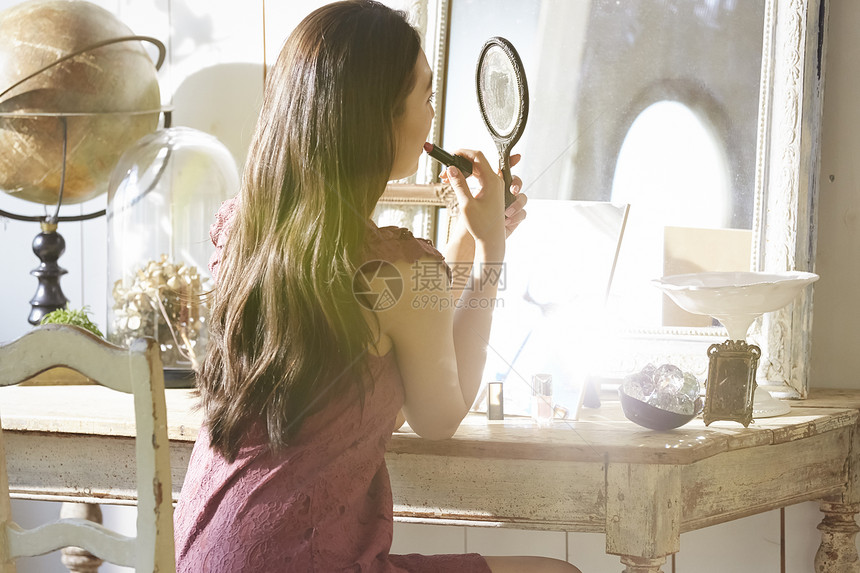 女人照镜子涂口红化妆图片
