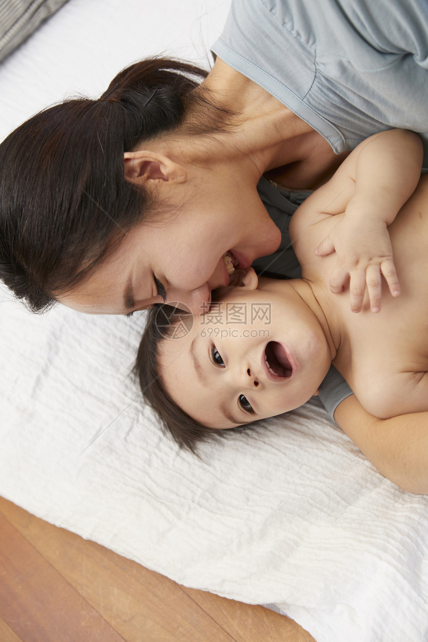 母亲亲吻赤裸上身的婴儿图片
