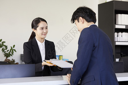 接待处的前台女子微笑服务登记图片