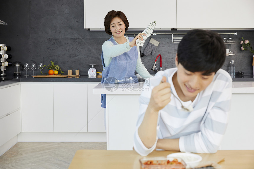 厨房里拿着抹布的家庭主妇图片