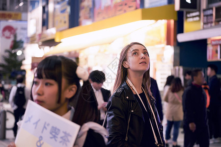 在东京晚上外国妇女观光享受高清图片素材