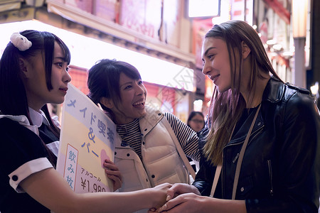 欢闹愉快旅行者与东京佣人握手散步高清图片素材