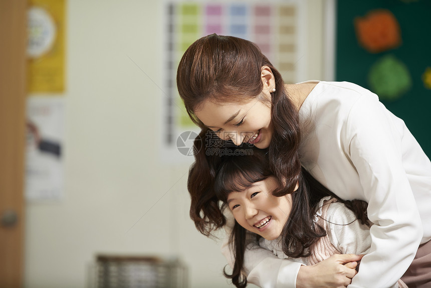 老师开心的抱着小女孩图片