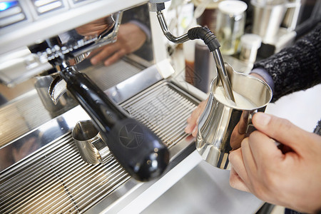 制作奶泡的咖啡师特写高清图片