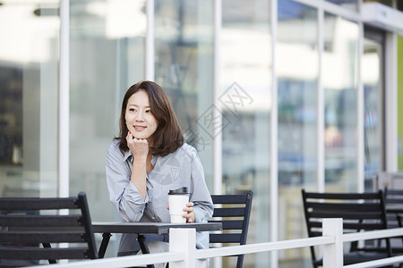 户外咖啡馆休息喝咖啡的年轻女子图片