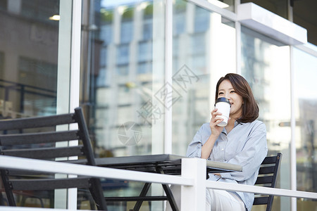 户外咖啡厅喝咖啡的女青年窗高清图片素材
