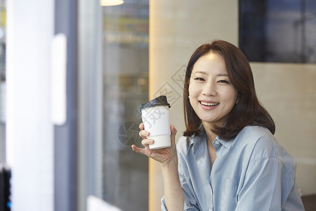 拿着咖啡杯微笑的成年女子成人高清图片素材