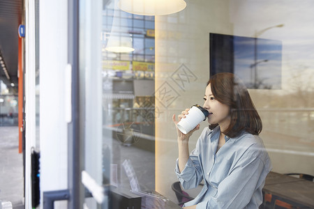 坐在窗边喝咖啡的青年女子杯子高清图片素材
