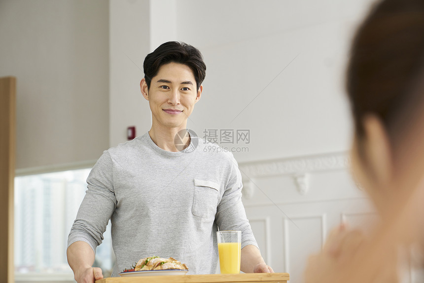 端着早餐微笑的成年男子图片